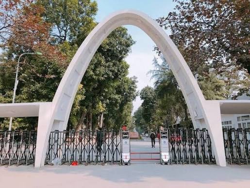 Cổng Parabol nhìn thẳng từ đường Giải Phóng, vòm cong trắng bắc qua lối vào và hàng rào xếp đóng kín phía dưới.